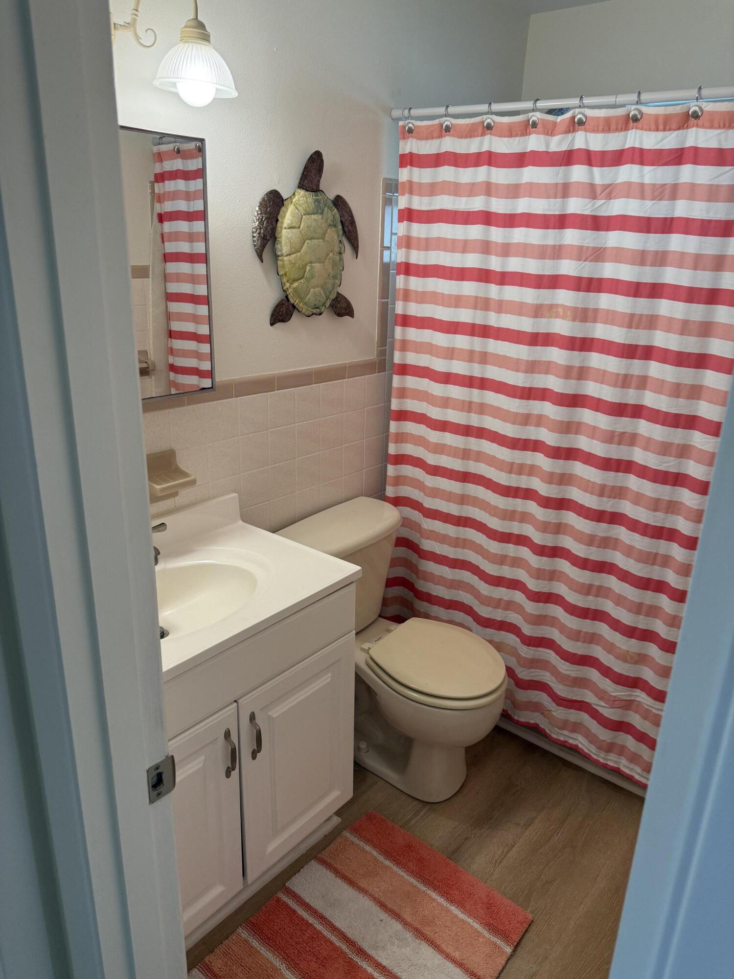 440 Southeast Fini Drive Stuart, FL 34996 - Photo 13 of 17 a bathroom with a sink a toilet and shower curtain