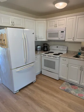 a white refrigerator freezer sitting in a kitchen
