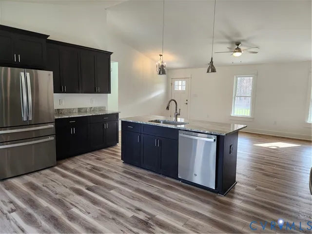 a kitchen with kitchen island granite countertop wooden cabinets and refrigerator