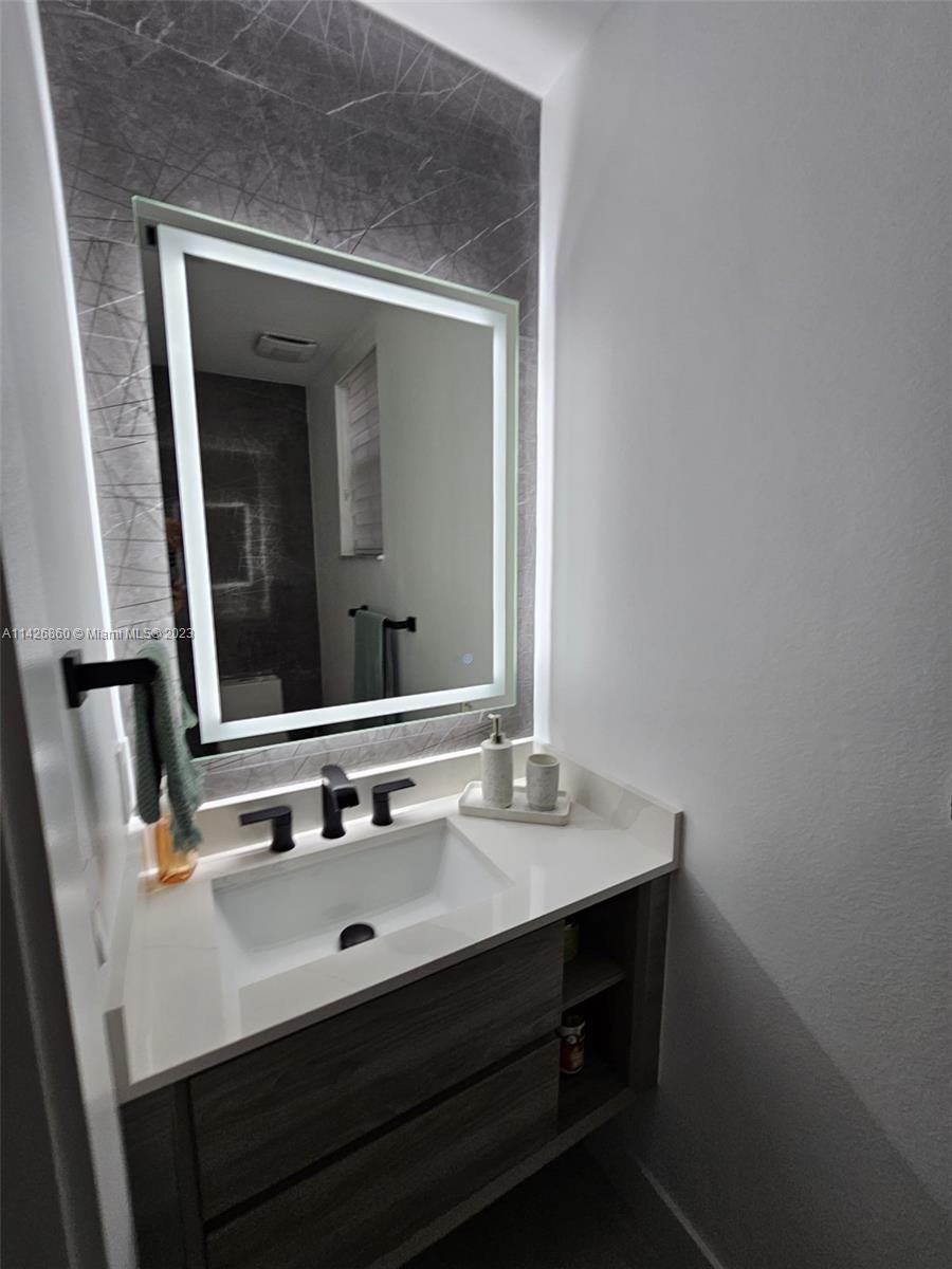3166 Southwest 155th Avenue Miami, FL 33185 - Photo 12 of 27 a bathroom with a sink vanity and mirror