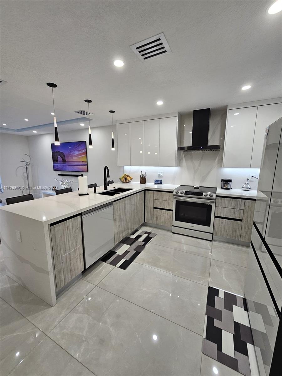 3166 Southwest 155th Avenue Miami, FL 33185 - Photo 7 of 27 a kitchen with stainless steel appliances granite countertop a sink stove and microwave