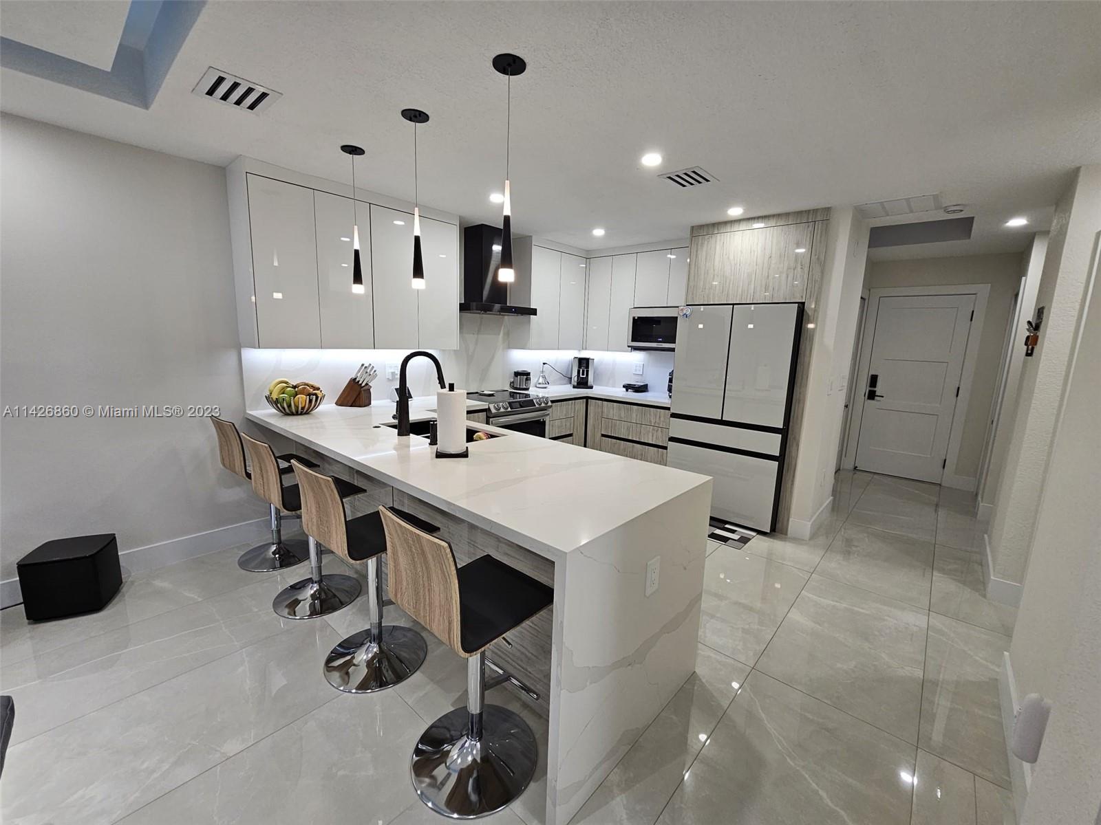 3166 Southwest 155th Avenue Miami, FL 33185 - Photo 9 of 27 a kitchen with kitchen island a appliances dining table and chairs