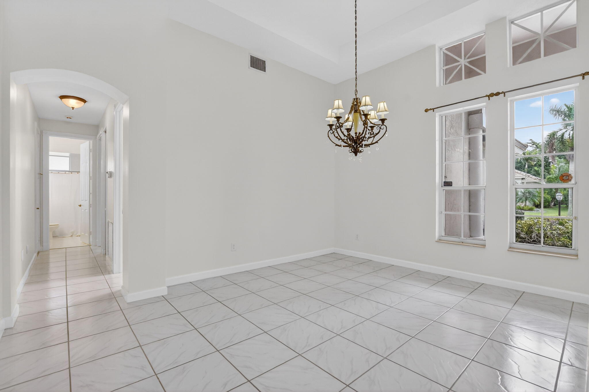 21719 Marigot Drive Boca Raton, FL 33428 - Photo 6 of 53 an empty room with windows and chandelier