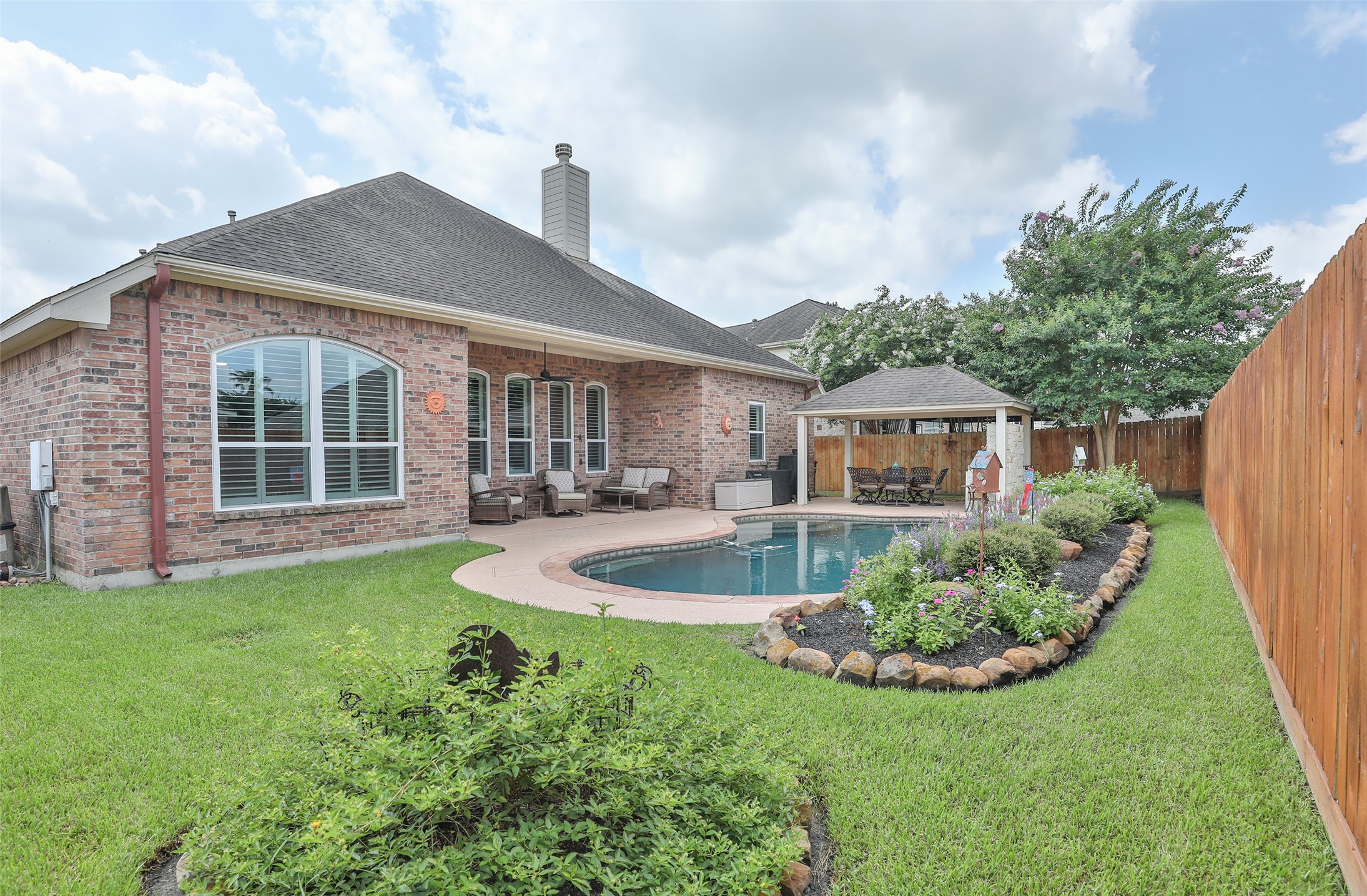 20519 Windrose Bend Drive Spring, TX 77379 - Photo 3 of 37 This backyard is an owner's dream! It features a covered back porch for relaxing, a sparkling pool to cool off in, and an additional covered patio complete with an outdoor kitchen —the perfect spot for entertaining guests or watching the big game.