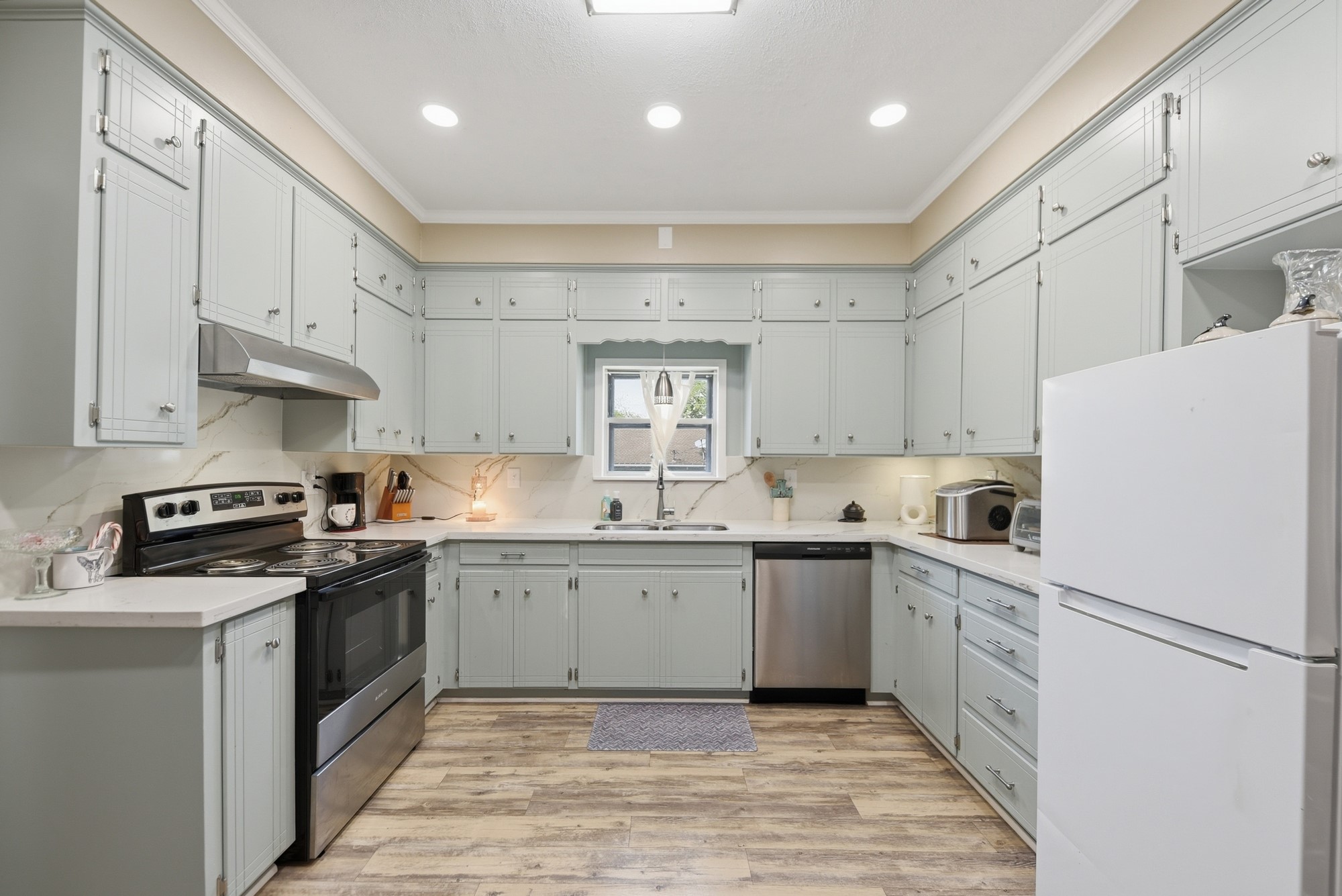 1501 South Austin Street Brenham, TX 77833 - Photo 5 of 36 a kitchen with white cabinets and white appliances