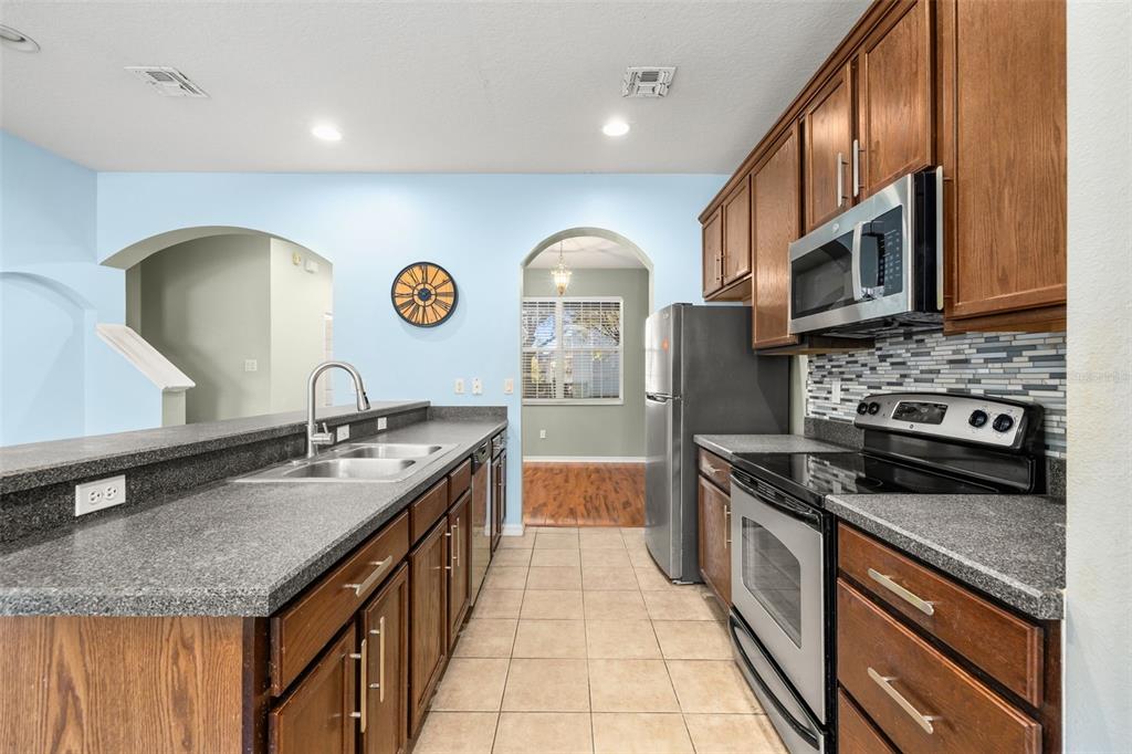 11781 Fitzgerald Butler Road Orlando, FL 32836 - Photo 13 of 37 a kitchen with stainless steel appliances granite countertop a stove a sink and a microwave