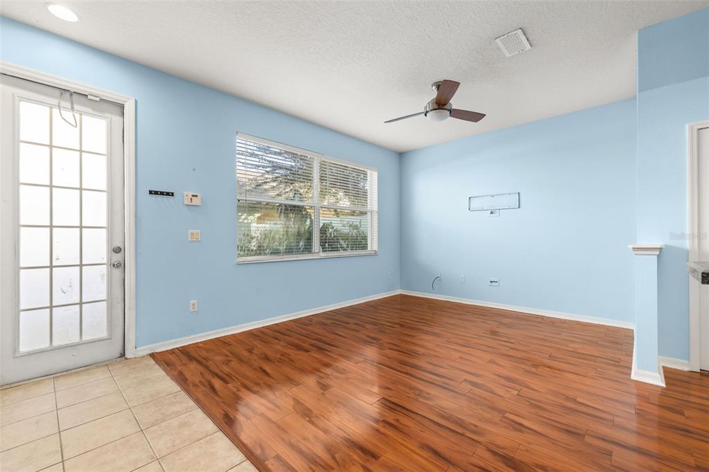 11781 Fitzgerald Butler Road Orlando, FL 32836 - Photo 16 of 37 an empty room with wooden floor chandelier fan and windows
