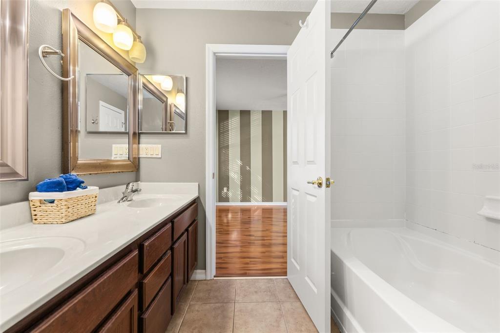 11781 Fitzgerald Butler Road Orlando, FL 32836 - Photo 25 of 37 a bathroom with a tub sink and mirror