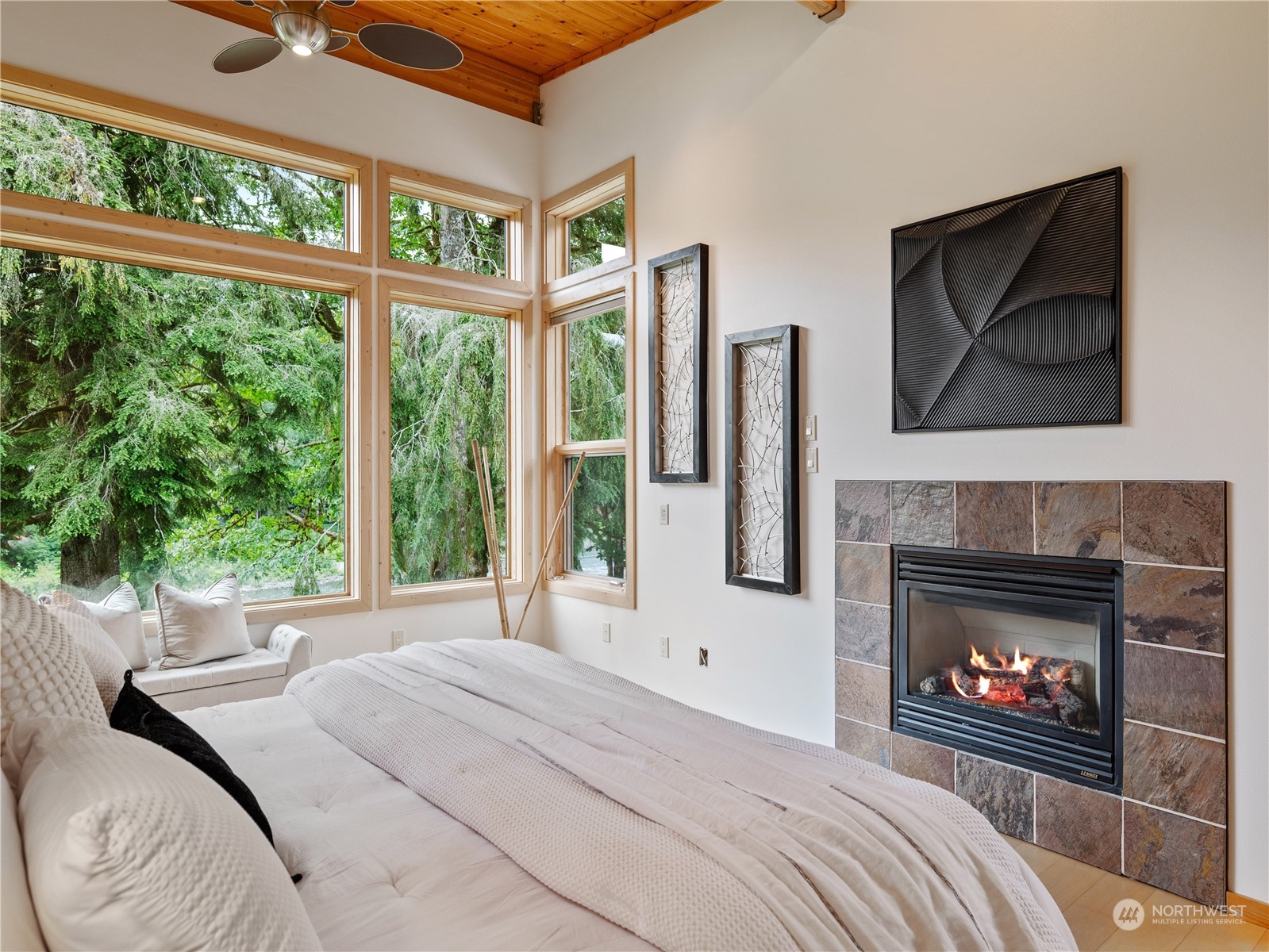51417 South Riverside Road Gold Bar, WA 98251 - Photo 25 of 40 a bedroom with a bed a fireplace and a large window