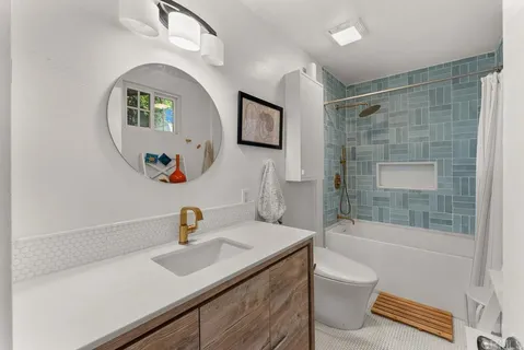 a bathroom with a sink a toilet and shower