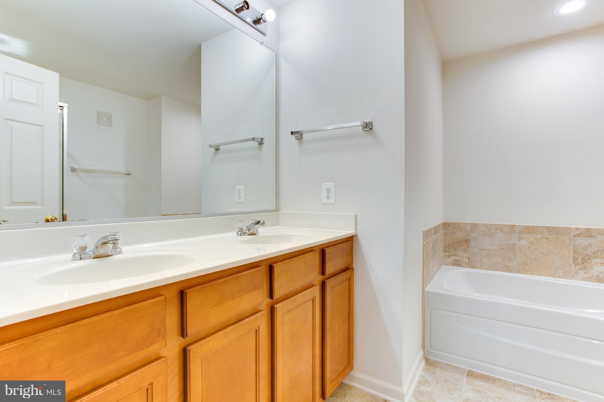 6020 Machen Road, Unit 177 Centreville, VA 20121 - Photo 26 of 30 a bathroom with a tub sink and mirror