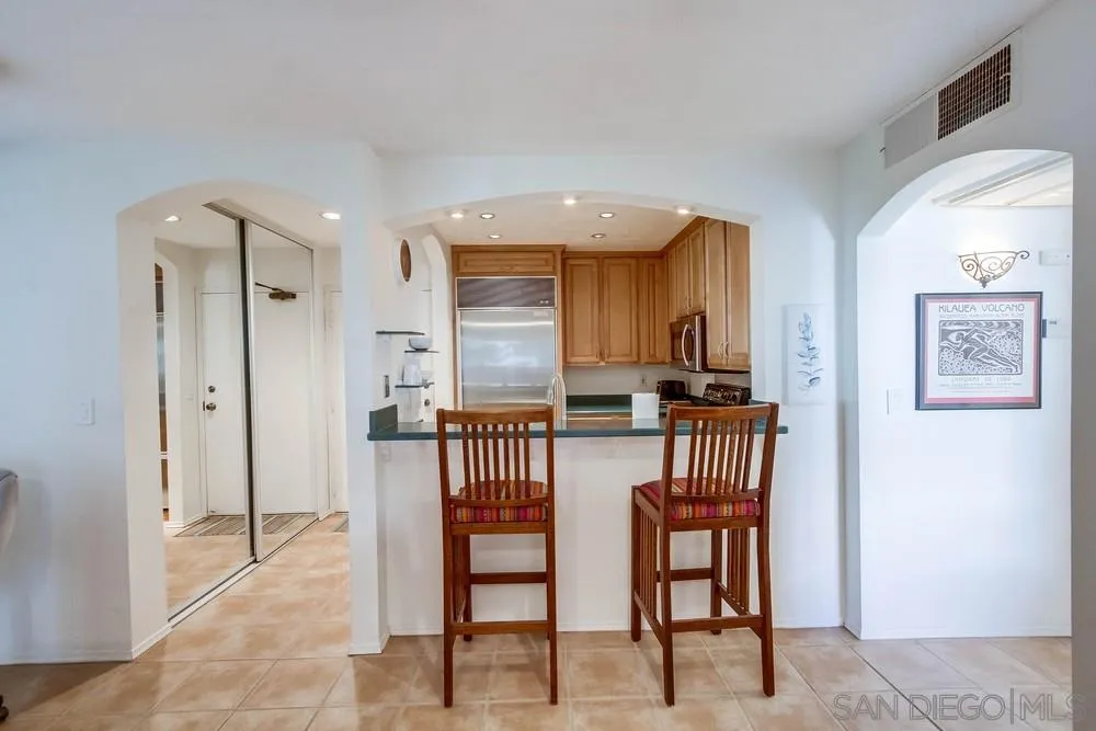 6767 Friars Road, Unit 150 San Diego, CA 92108 - Photo 4 of 20 a kitchen with stainless steel appliances kitchen island granite countertop refrigerator and cabinets