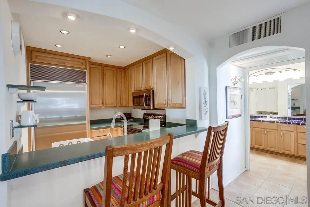 6767 Friars Road, Unit 150 San Diego, CA 92108 - Photo 5 of 20 a kitchen with stainless steel appliances kitchen island granite countertop a table and chairs