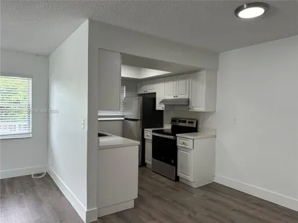 a kitchen with a stove a sink and a refrigerator