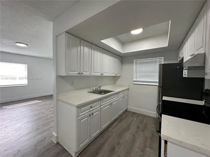 a kitchen with a sink appliances and cabinets