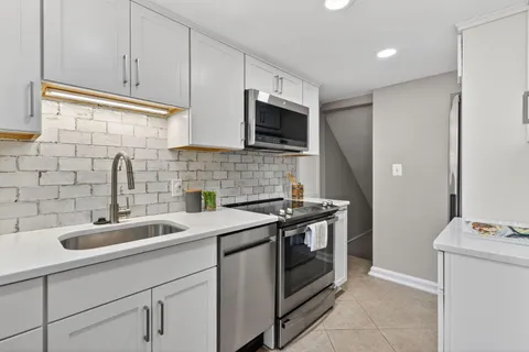 a kitchen with a sink stove and cabinets