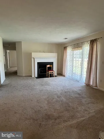 an empty room with fireplace and windows