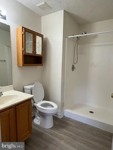 a bathroom with a toilet a sink a shower and mirror
