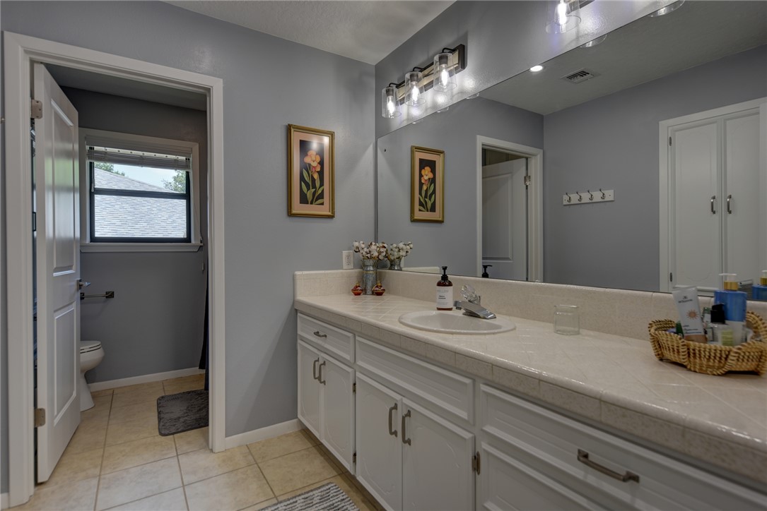 1600 Pecan Street Brenham, TX 77833 - Photo 16 of 33 Bathroom with large vanity, toilet, tile floors, and baseboards