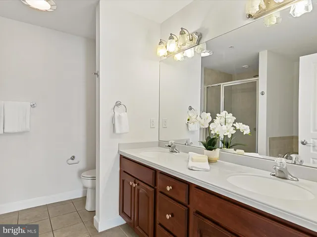 a bathroom with a sink a toilet a mirror and shower