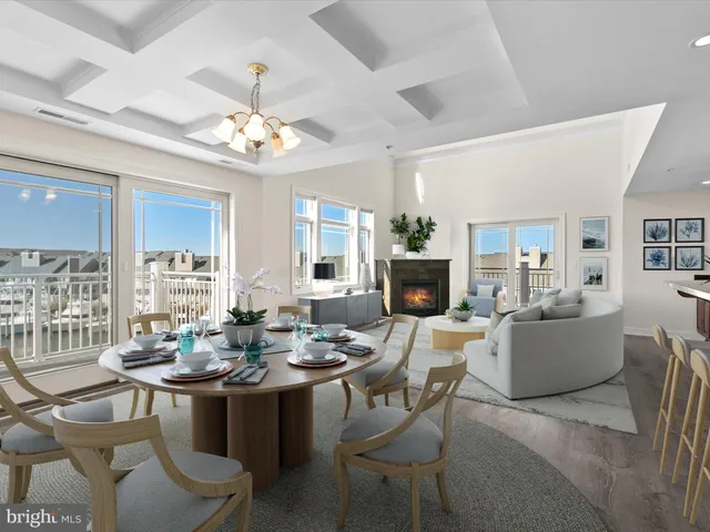 a view of an empty room with wooden floor and a fireplace