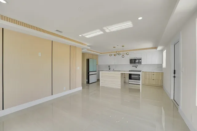 a view of kitchen with stainless steel appliances refrigerator cabinets and stove top oven