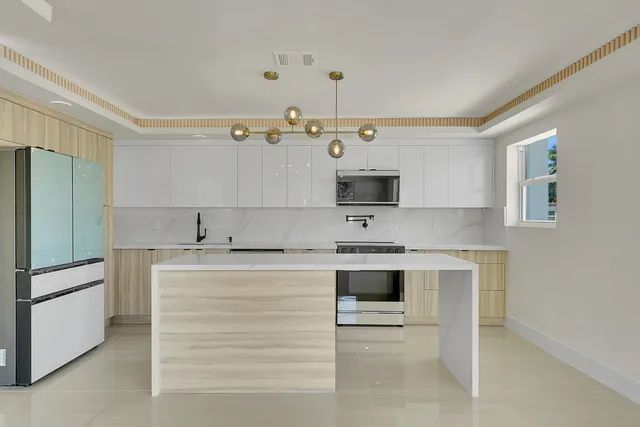 a kitchen with stainless steel appliances a sink stove and refrigerator
