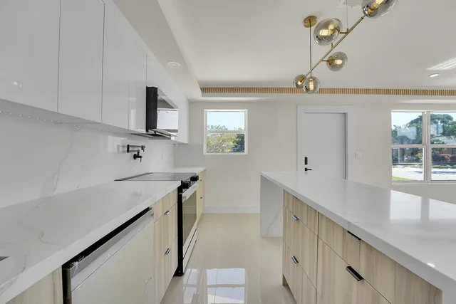 a kitchen with stainless steel appliances a stove refrigerator sink and cabinets