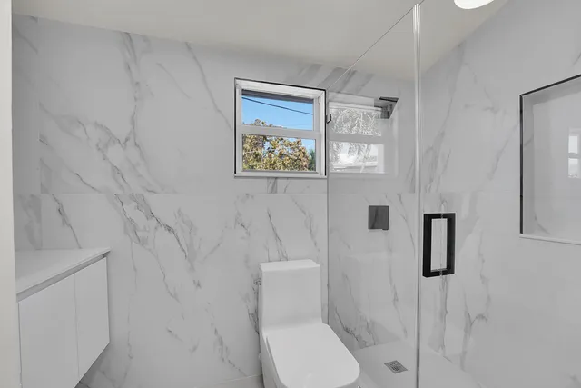 a view of an house with backyard and bushes