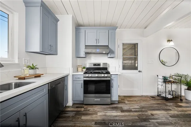 a kitchen with stainless steel appliances granite countertop a sink stove and cabinets