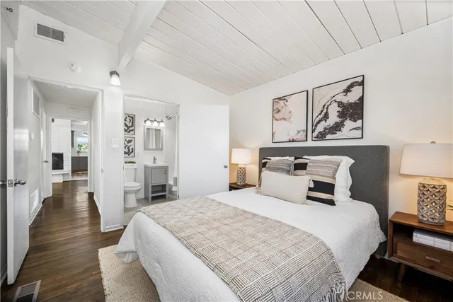 a bedroom with a large bed and a chandelier