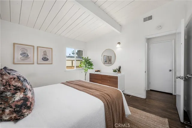 a bedroom with a large bed and a wooden floor