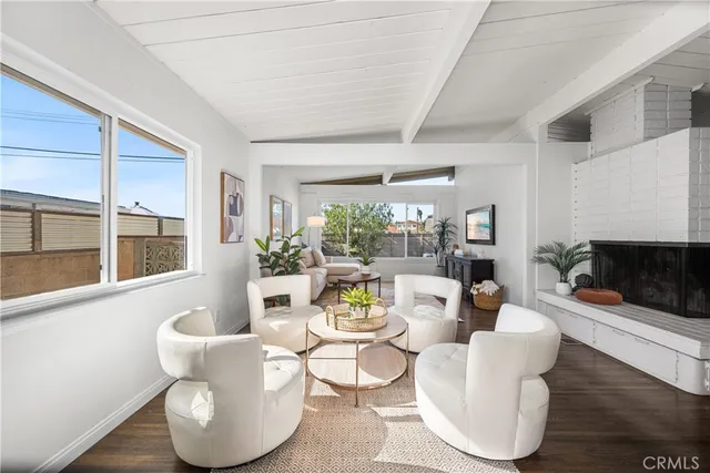 a living room with fireplace furniture and a large window
