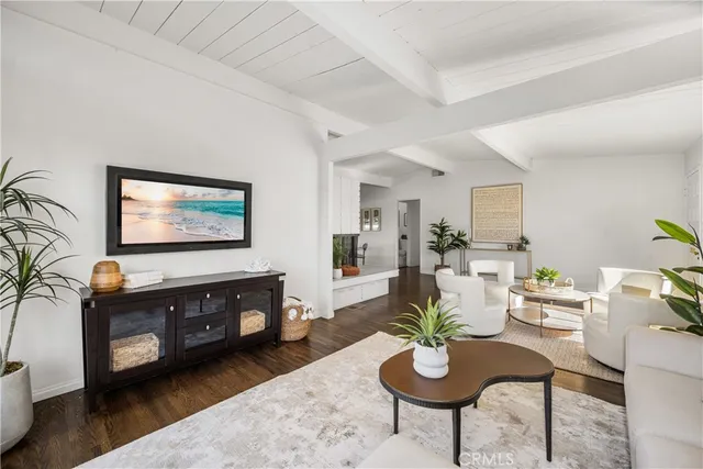 a living room with furniture a mirror and a flat screen tv