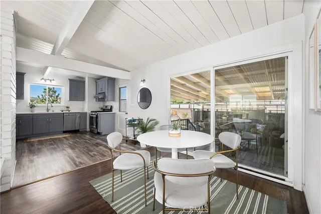 a living room with furniture a large window and wooden floor
