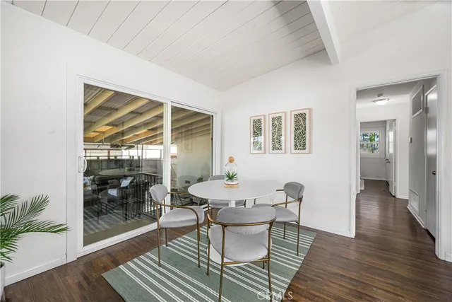 a dining room with wooden floor and glass door