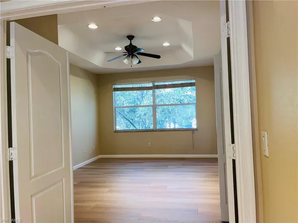 a view of empty room with wooden floor and fan