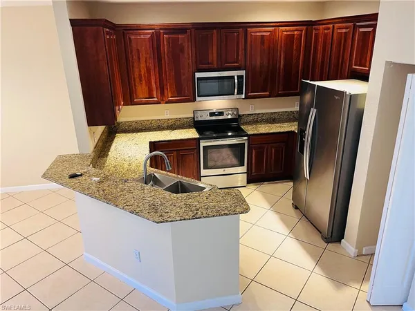 a kitchen with stainless steel appliances granite countertop a refrigerator stove and microwave