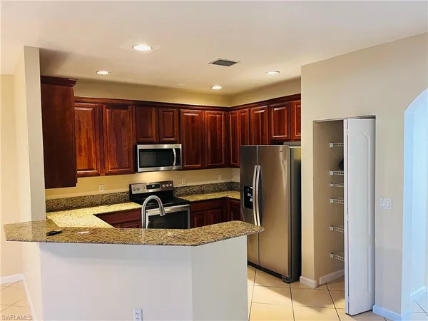 a kitchen with granite countertop a refrigerator and a sink