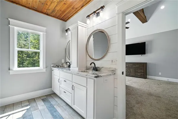 a bathroom with a granite countertop shower a sink and a window