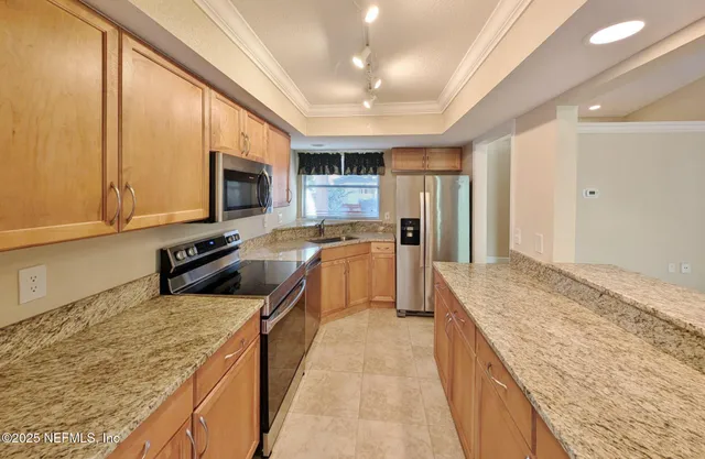 a kitchen with stainless steel appliances granite countertop a stove a sink and a refrigerator