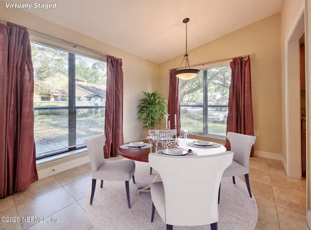 a dining room with furniture a chandelier and wooden floor