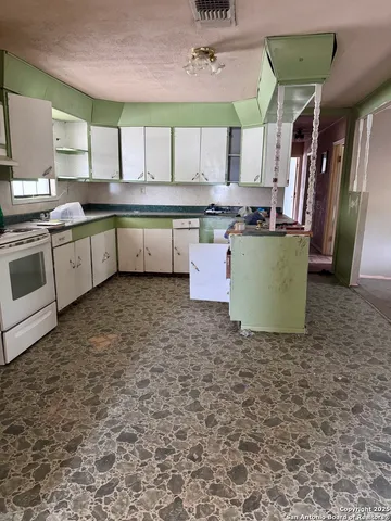 a kitchen with a sink a stove and cabinets