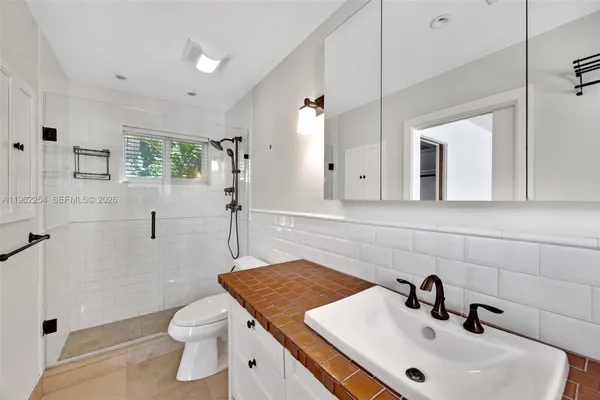 a bathroom with a sink a toilet and shower