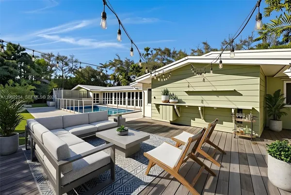 a view of a patio with couches table and chairs with wooden floor and fence