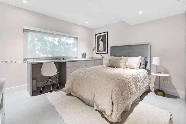 a bedroom with a bed a table and painting