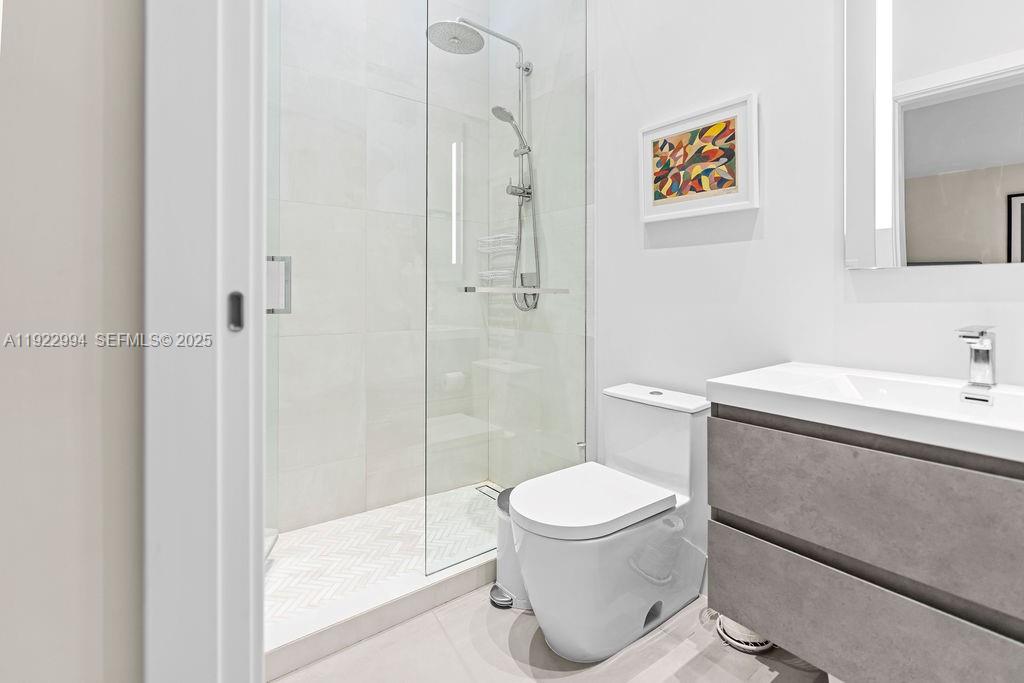 4095 Battersea Road Miami, FL 33133 - Photo 31 of 82 a bathroom with a toilet sink and shower