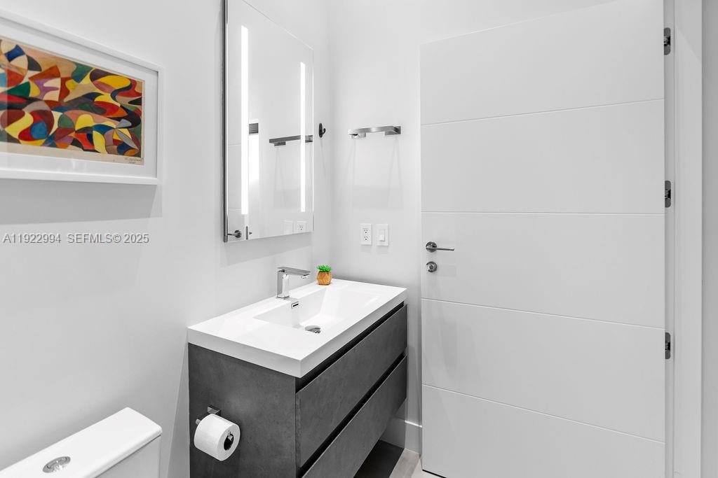 4095 Battersea Road Miami, FL 33133 - Photo 33 of 82 a bathroom with a sink and a mirror