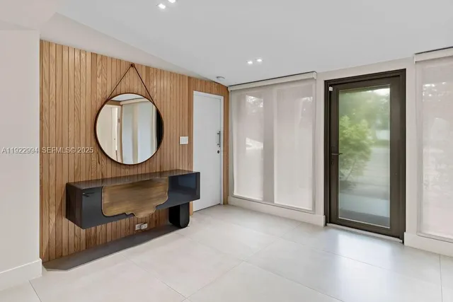 a view of a patio with table and chairs potted plants with floor to ceiling window and potted plants