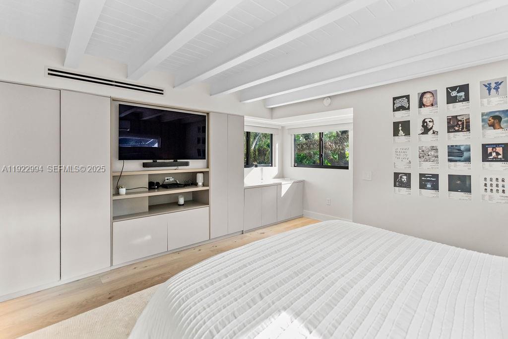 4095 Battersea Road Miami, FL 33133 - Photo 50 of 82 a bedroom with a bed and a flat screen tv